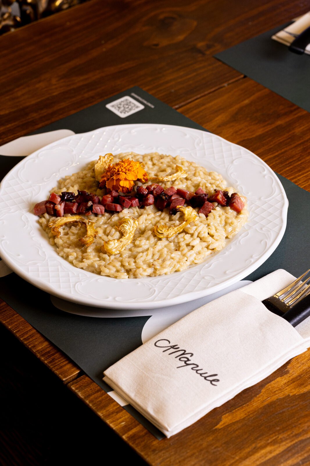 Risotto servido con servilleta bordada con la marca A'Napule — pieza editorial para redes sociales