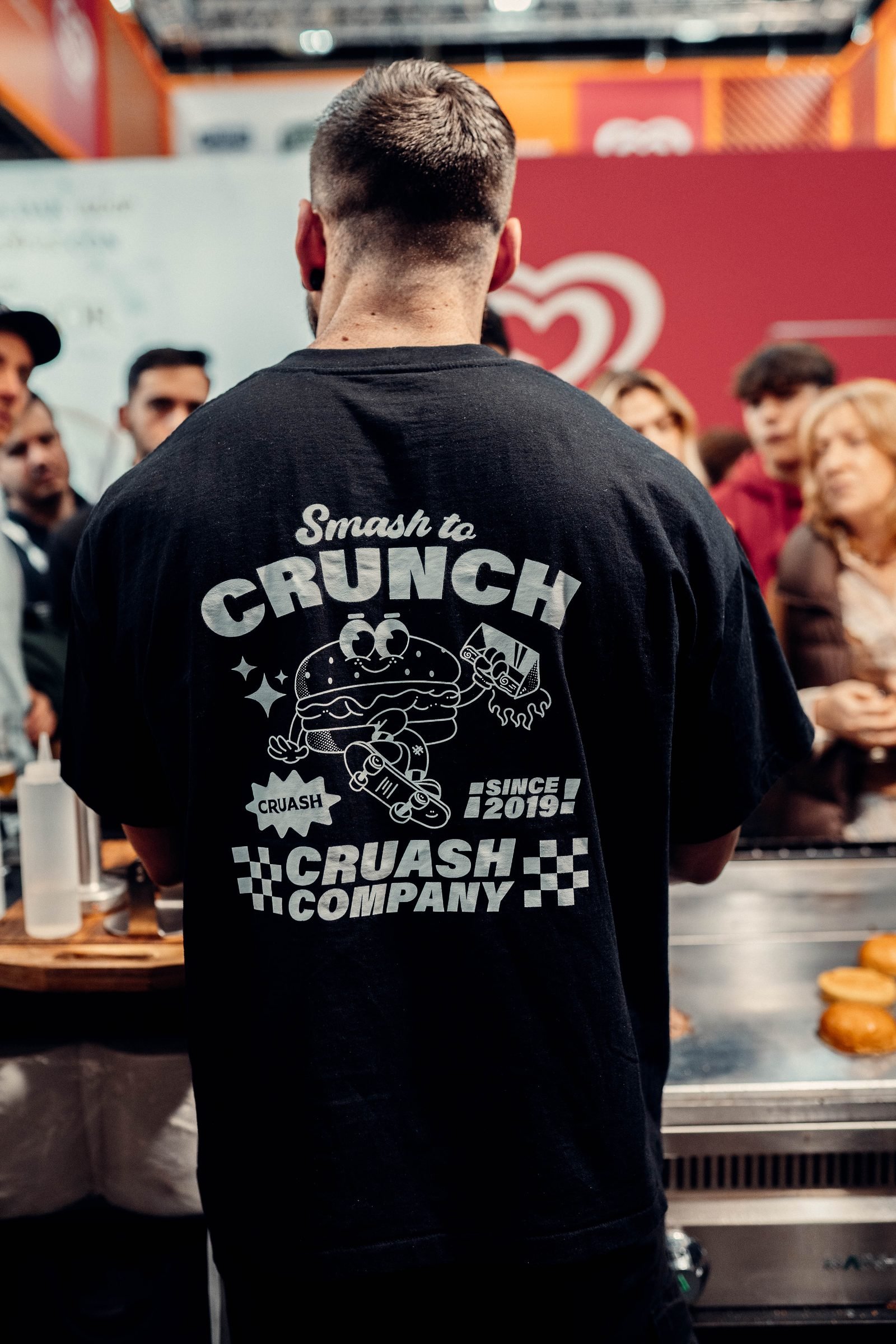 T-shirt del merchandising CRUASH con mascot Smash to Crunch y tagline CRUASH COMPANY SINCE 2019 en la espalda
